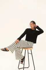 Pantalón ancho de tejido de punto, con diseño de rayas horizontales en blanco y negro. Presenta cintura elástica con cordón ajustable.