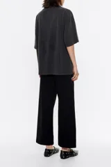 Pantalón vaquero negro de corte barrel, tiro medio y largo tobillero. Incluye cinturón de tela ajustable con pespuntes.