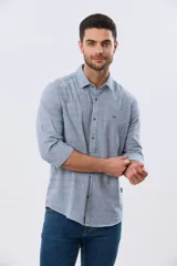 Camisa de manga larga confeccionada en mezcla de lino y algodón, con sutiles rayas celestes, cuello camisero clásico y cierre frontal de botones.