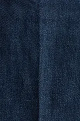 Jean de denim azul oscuro, de tiro alto y piernas amplias con pliegues frontales y traseros. Cuenta con cierre y doble botón metálico en la cintura.