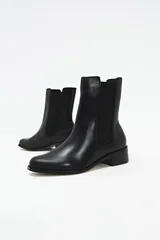 Botinetas negras de cuero con elástico lateral y taco bajo.