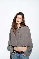 Camisa corta de manga larga con cuello solapa, confeccionada en tela con estampado de cuadros vichy en color bordó y blanco. Presenta un bolsillo delantero de plastrón, cierre frontal con botones y bajo abullonado con elástico interior.