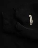 Canguro negro con capucha y cierre frontal, con texto bordado en el pecho y bolsillos laterales.