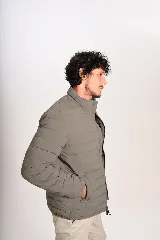 Campera puffer verde militar, de cuello alto, con cierre frontal y bolsillos laterales.