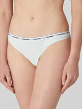 Colaless de tiro medio, color celeste pálido, con cintura elástica blanca que lleva el logo de Calvin Klein repetido en gris.