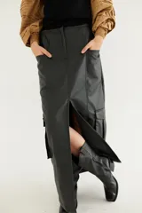 Falda midi de cuerina color marrón oscuro, corte recto, con bolsillos laterales y abertura frontal.