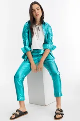 Pantalón de lino metalizado color turquesa, con cintura elástica, corte pitillo, bolsillos laterales y traseros.