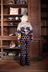 Pantalón de corte evasé confeccionado en tela calada con diseño de círculos de terciopelo. Presenta cintura elástica con cierre y un calce holgado y cómodo.