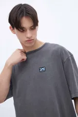 Remera blanca de algodón con calce oversize, teñida en prenda, con parche chico en el pecho y diseño fotográfico de dos tragos en la espalda.