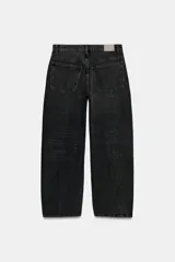 Jeans de tiro medio con diseño baggy barrel, cinco bolsillos y costuras laterales torcidas. Presenta cierre frontal con cremallera y botón metálico.