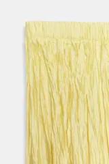 Falda larga de tiro medio color amarillo, con cintura elástica, diseño plisado y bajo asimétrico.