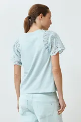 Remera color verde agua con mangas cortas de broderie.