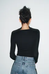 Camiseta de manga larga en color marrón oscuro, confeccionada en tejido de algodón. Presenta un diseño de corte ajustado (slim fit) con cuello redondo.