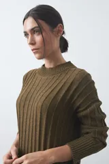 Vestido midi de punto en color gris, con diseño de tejido acanalado vertical, cuello redondo y mangas largas. Presenta una silueta recta y fluida.