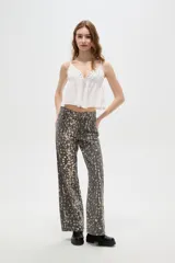 Pantalon de jean de corte ancho y tiro alto, con estampado tipo animal print desgastado en tonos gris y blanco.