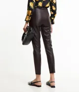 Pantalón skinny de cuero sintético color marrón oscuro, con cierre y botón en la cintura, bolsillos delanteros y traseros, y recortes en las rodillas.