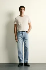 Jeans de corte recto en tono azul clásico con efecto lavado, tiro medio y diseño de cinco bolsillos con cierre frontal de botones.