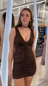 Vestido corto marrón con brillos, escote en V pronunciado, diseño sin mangas y fruncido en todo el cuerpo.