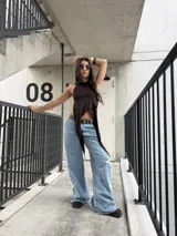 Jeans rígido de corte wide leg, tiro medio y color celeste, con diseño de estrellas grandes desflecadas en los laterales de las piernas.