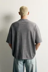Remera de corte relaxed fit con efecto lavado, cuello redondo y manga corta, con estampado frontal contrastante.