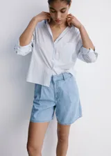 Short de denim color celeste con pinzas en la parte delantera y bolsillos laterales, de corte recto y tiro regular.