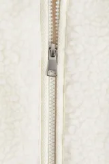 Chaleco de sherpa suave con cierre frontal, bolsillos tipo parche y ribetes de cinta finos. Cuenta con forro interior.