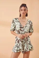 Mono corto color verde agua con estampado de hojas en marrón, escote en V, mangas cortas abullonadas con elástico y cintura elastizada.