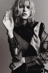 Broche tipo aguja con diseño de flor en relieve, decorado con aplicaciones de cristales brillantes sobre una base metálica plateada.