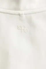 Campera deportiva crop con cuello alto, cierre frontal completo y mangas largas con abertura para el pulgar.
