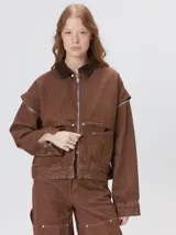 Campera de denim a rayas verticales con cuello de pana en color bordó. Presenta cierre frontal, mangas desmontables con cierre en los hombros, canesú en el pecho y bolsillos de parche cuadrados.