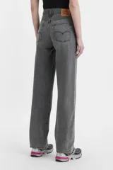 Jean de corte baggy y tiro medio, con diseño de costuras retorcidas y abertura en el ruedo. Presenta cierre de botones a la vista y un acabado lavado en tono gris.