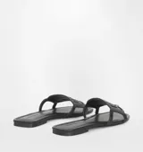 Sandalia plana negra de goma con diseño de ojo característico de la marca Chiara Ferragni en la tira superior.