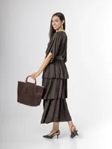 Vestido midi de crepé color marrón, con escote en V, mangas cortas amplias, cintura elastizada con lazo ajustable y falda larga escalonada con volados.