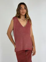 Chaleco tejido de punto color ladrillo, con escote en V y terminaciones desflecadas.