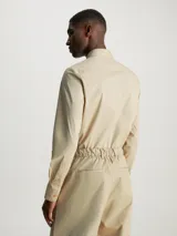 Camisa de vestir color beige, de corte slim, con cuello clásico y cierre frontal con botones.