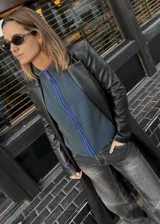 Campera tejida con textura vanizada a rayas verticales en color lila y negro, con cierre frontal y cuello alto.