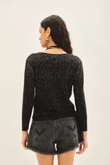 Cardigan negro con escote en V, manga larga y cierre frontal con botones. Presenta un diseño con aplicación de tachas plateadas distribuidas por toda la prenda.