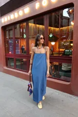 Vestido largo de denim azul, de corte recto y holgado, con tirantes finos y tajo lateral en la parte inferior.