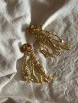 Aros colgantes hechos a mano con bronce, porcelana, piedras y otros materiales que le dan textura. Cada par es único e irregular.
