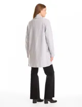 Cardigan largo de tejido de punto suave, color gris, con cuello con caída fluida, mangas largas con hombros caídos y bolsillos laterales discretos.
