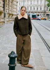 Pantalón wide leg de tiro medio en color verde militar, con diseño de pinzas, trabillas y bolsillos laterales. Cuenta con cierre delantero oculto.