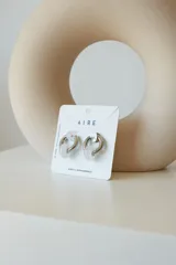 Aros de argolla en acero quirúrgico con dije de piedra natural en tono azul.