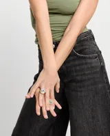 Anillo tipo sello plateado con forma de ojo y cristal facetado azul.