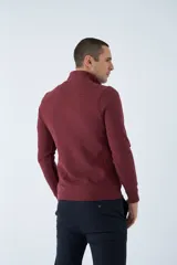 Buzo de hombre color bordó, con medio cierre frontal, cuello alto y logo estampado en el pecho. De corte regular y manga larga.