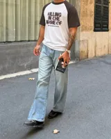 Remera estilo raglan con cuerpo blanco y mangas cortas marrones, con diseño gráfico inspirado en Rage Against The Machine y la frase 'Killing In The Name Of' en el frente.