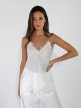 Top de lino color blanco con tirantes finos y detalles de encaje en el escote en V y en el ruedo.