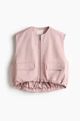 Chaleco de sarga marca H&M, color rosado, con escote redondo, cierre bidireccional y bolsillos delanteros con solapa. Modelo oversized con bajo globo para una silueta abullonada.