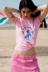 Remera rosa de algodón con estampa circular en azul con un caballo parado de manos y la leyenda "The Ranch Dress Code".