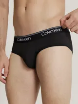 Pack de 3 slips Calvin Klein de corte clásico, confeccionados en tejido micro stretch de poliéster y elastano. Incluye tres slips negros con cinturas elásticas de diferentes colores: gris, dorado y blanco, con el logo de la marca.