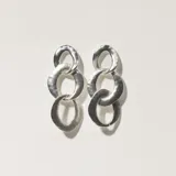 Aros colgantes plateados con tres eslabones ovalados texturizados.